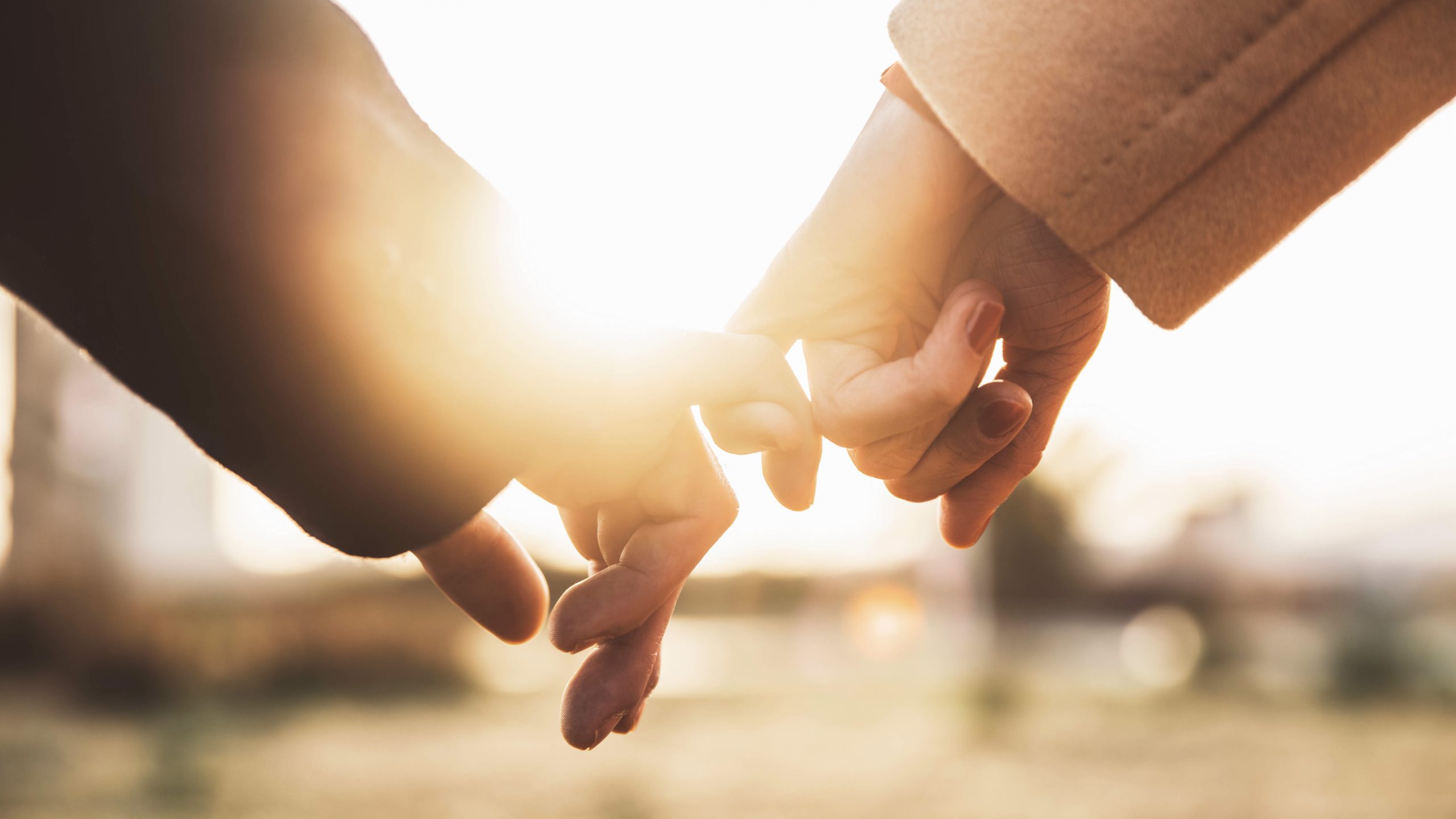 Closeup image of two lovers holding hands at sunset - Trust, love, relationship and support concept